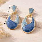 Boucles d’oreilles pendantes élégantes bleu et or portées pour une tenue habillée