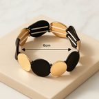 Bracelet noir et doré porté au poignet pour un look chic et moderne