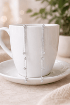 Détail des strass ronds sur chaîne fine argentée finition blanc K