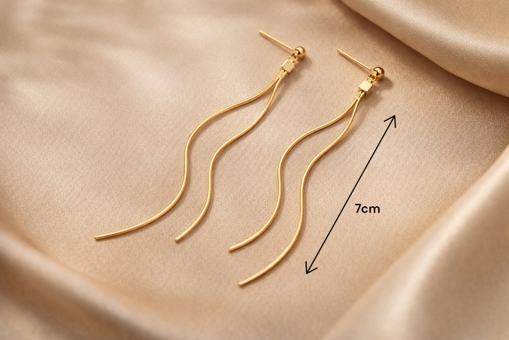 Boucles longues dorées portées avec tenue chic pour soirée ou mariage