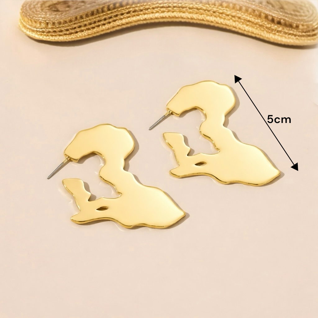 Boucles d'oreilles Afrique dorées portées avec tenue d'été chic