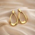 Détail des boucles d’oreilles goutte ajourées finition dorée brillante