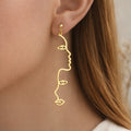 Boucles d’oreilles visage line art dorées longues minimalistes 7 cm