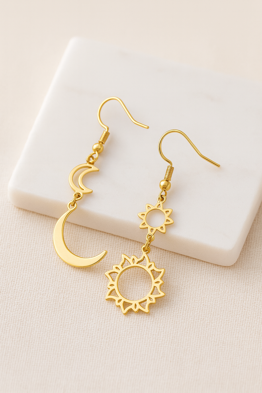 Détail des pendentifs ajourés soleil et croissant de lune finition dorée
