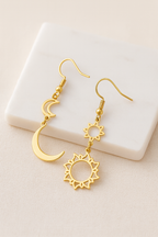 Détail des pendentifs ajourés soleil et croissant de lune finition dorée