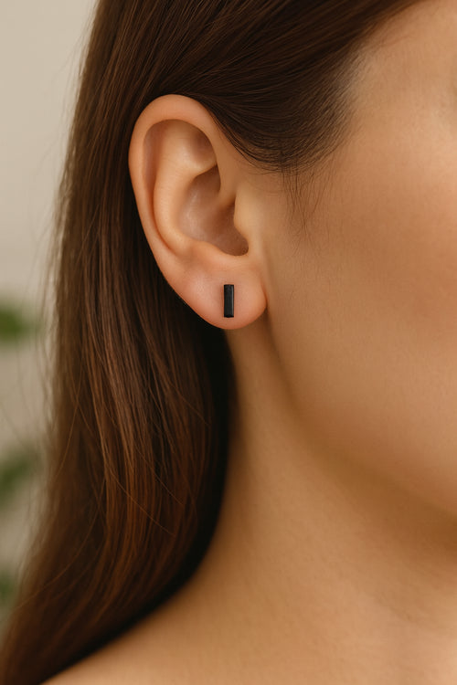 Détail de la puce d’oreille noire finition mate en forme de barre avec fermoir poussette