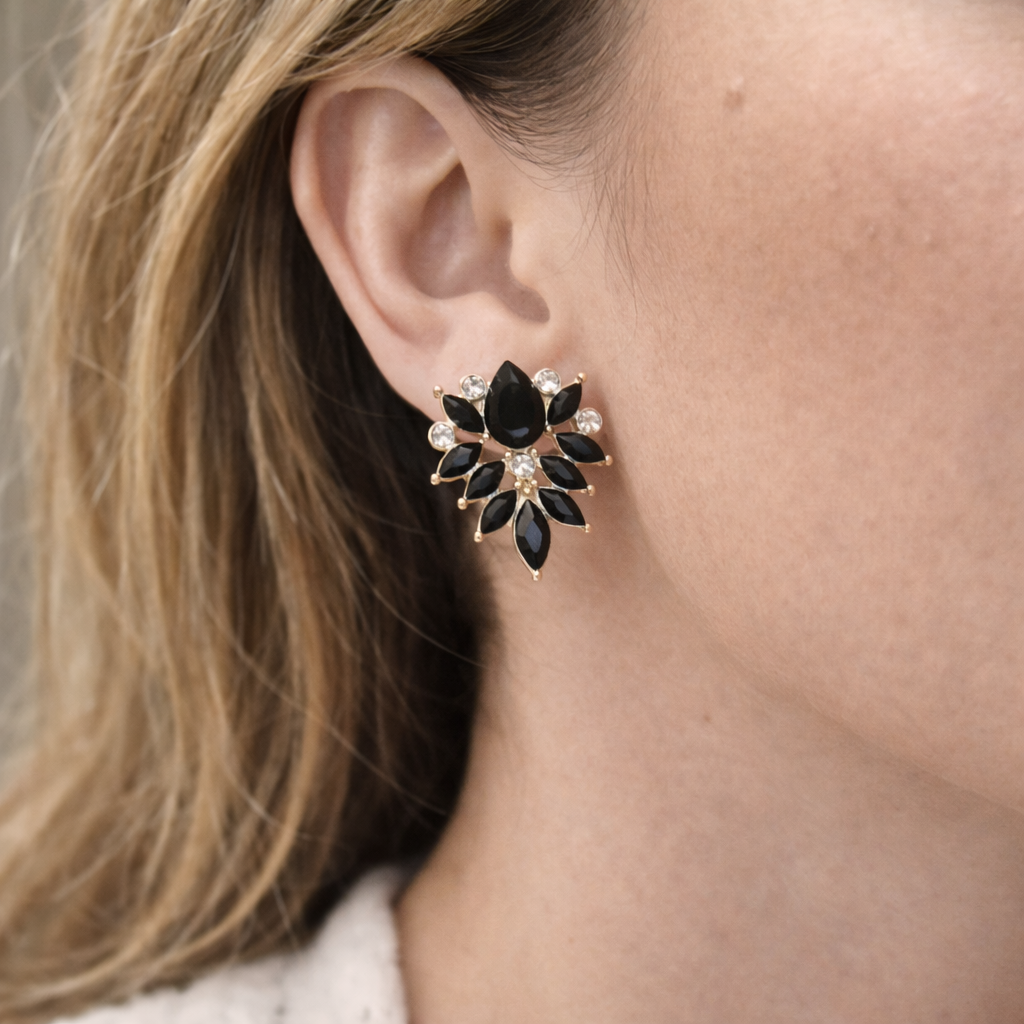 Boucles d'oreilles fleur noire dorée portées en puces avec cristaux