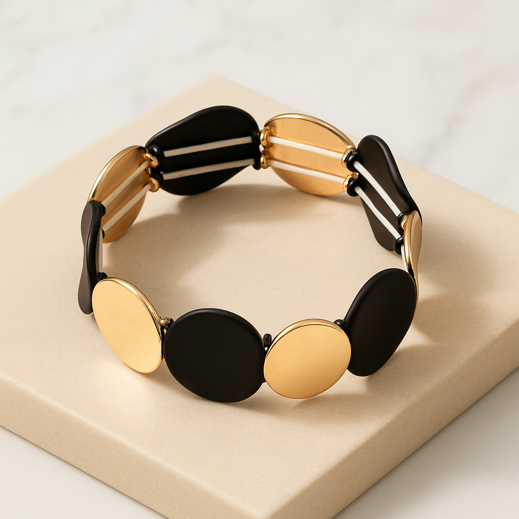 Détail des pastilles rondes noires mates et dorées brillantes du bracelet