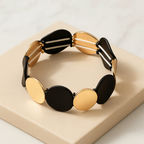 Détail des pastilles rondes noires mates et dorées brillantes du bracelet