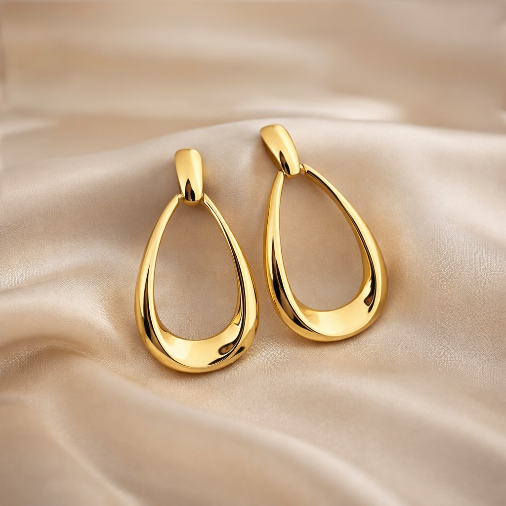 Détail des boucles d’oreilles goutte ajourées finition dorée brillante