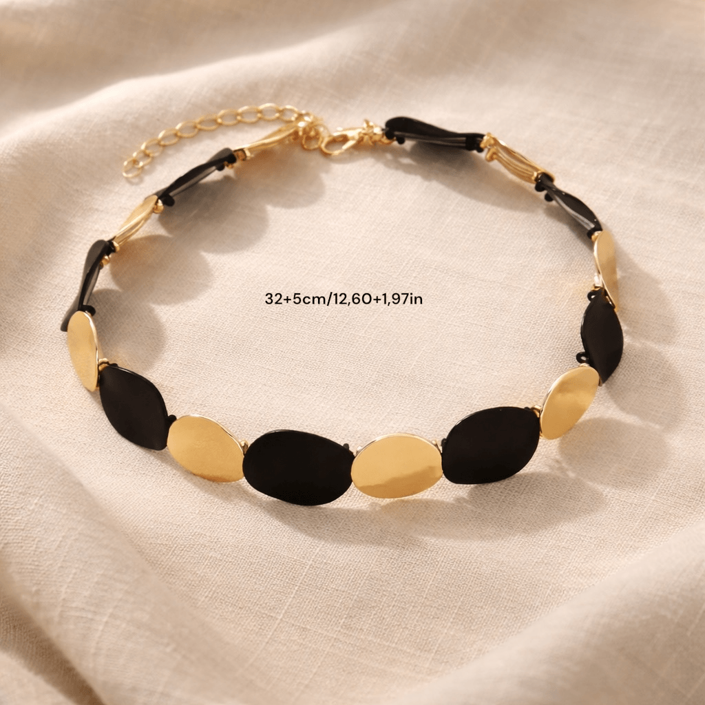 Collier minimaliste graphique noir et or ambiance élégante contemporaine