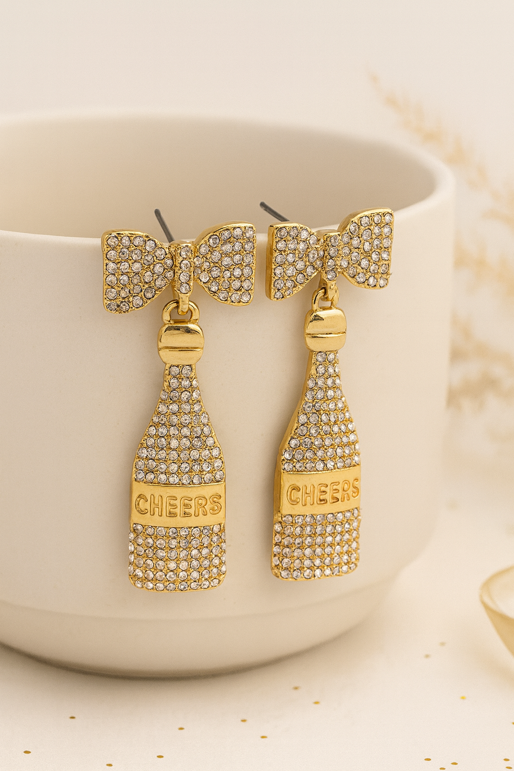 Détail nœud doré pavé de strass et bouteille de champagne scintillante