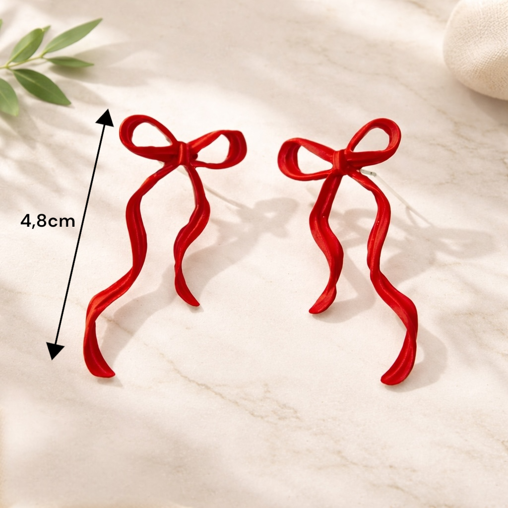Boucles d’oreilles pendantes rouges portées pour une tenue chic et féminine
