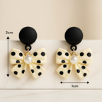 Boucles d’oreilles nœud à pois portées, accessoire rétro chic pour tenue femme