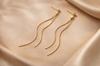 Détail des boucles pendantes ondulées finition dorée et fermoir clou