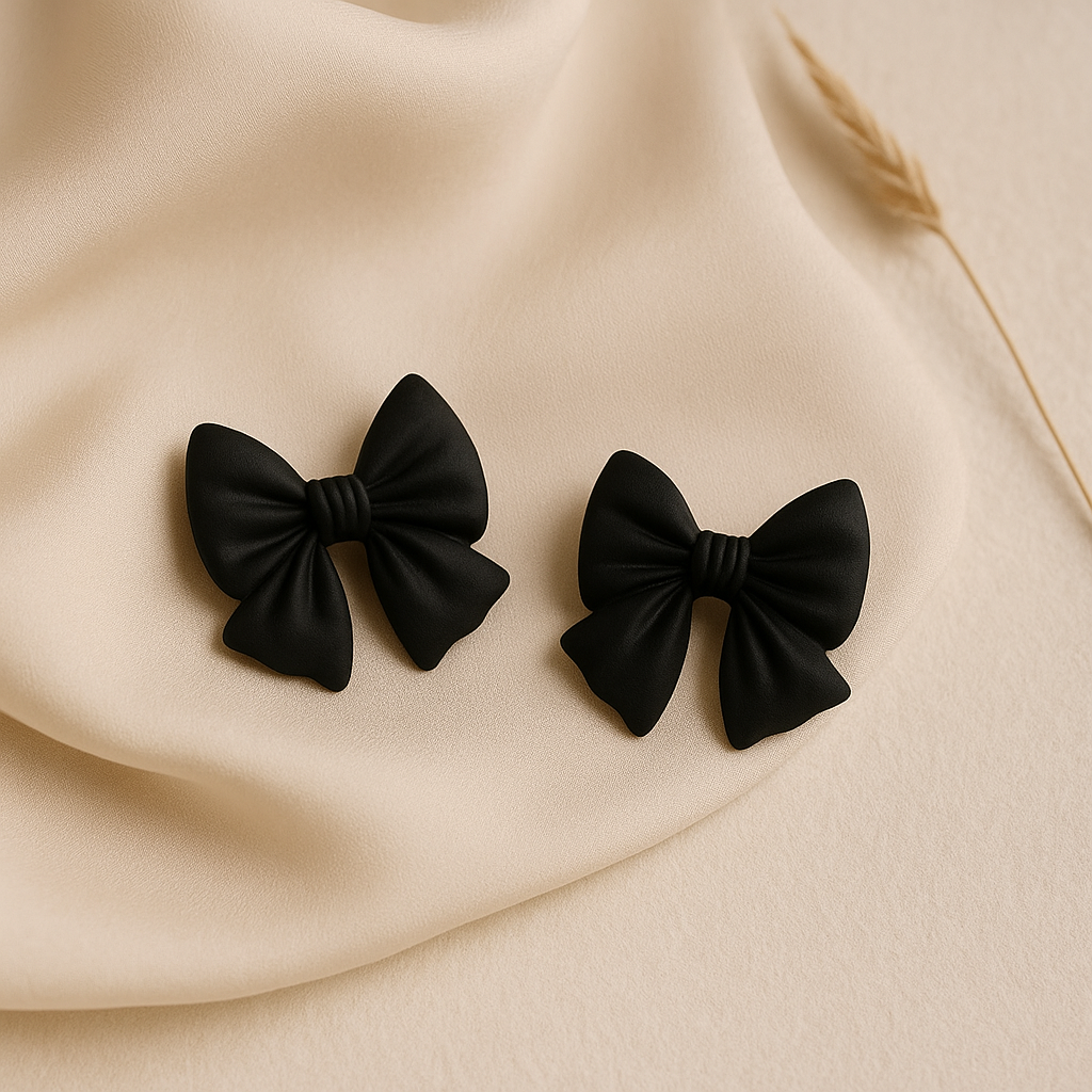 Détail des boucles d’oreilles en forme de nœud noir mat, style minimaliste