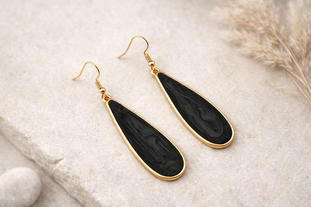 Détail des boucles goutte noire effet marbré avec contour doré