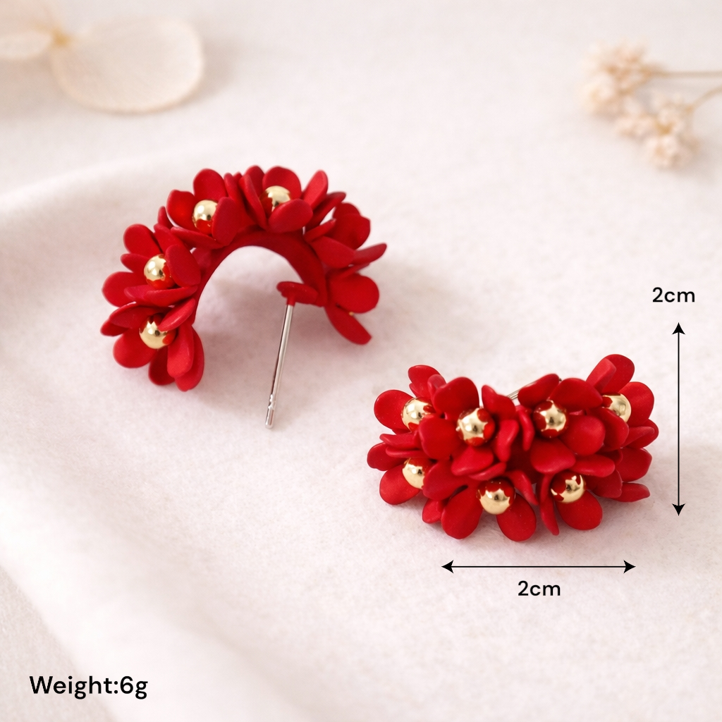 Boucles clous fleurs rouges portées pour une tenue chic romantique
