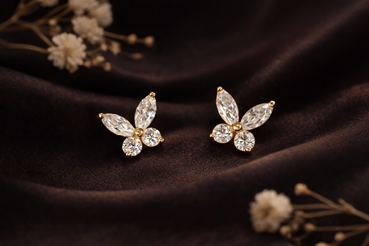 Détail des puces papillon avec pierres transparentes taille marquise et rondes sur finition dorée