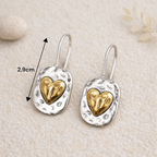 Boucles d’oreilles pendantes cœur bicolores pour femme en tenue chic