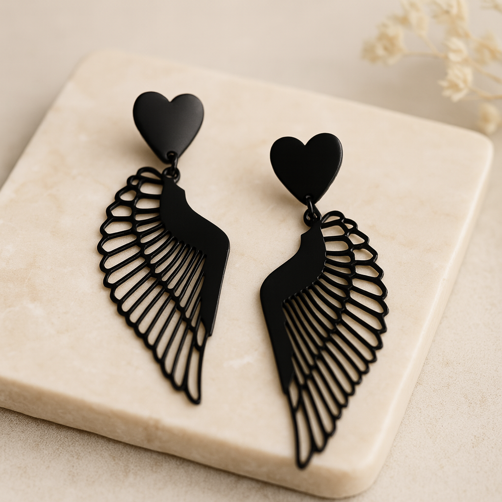 Détail du cœur noir brillant et de l’aile ajourée en métal noir